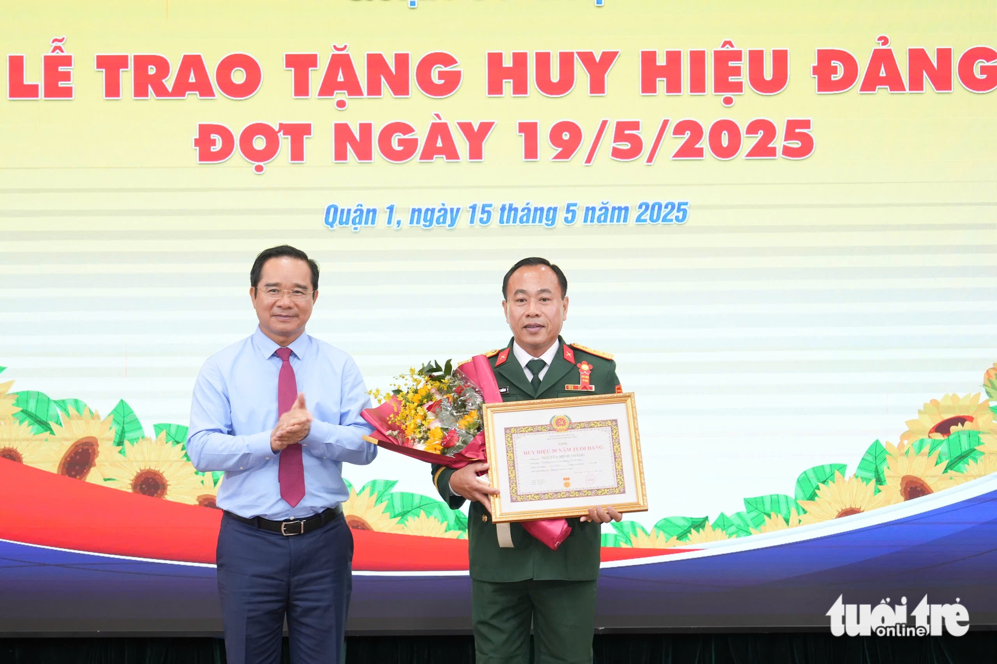 胡志明市人民委员会主席阮文德在第一郡颁发党徽
